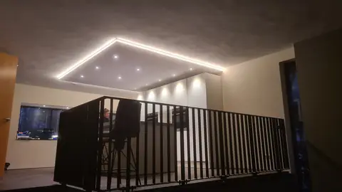 De keuken met het verlaagde plafond, gezien vanaf de overloop achter de stalen balustrade